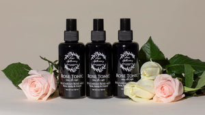 Three bottles of Rose Tonic with flowers on a neutral background
